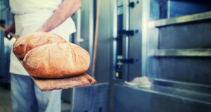 Bäcker in der Bäckerei mit Brot