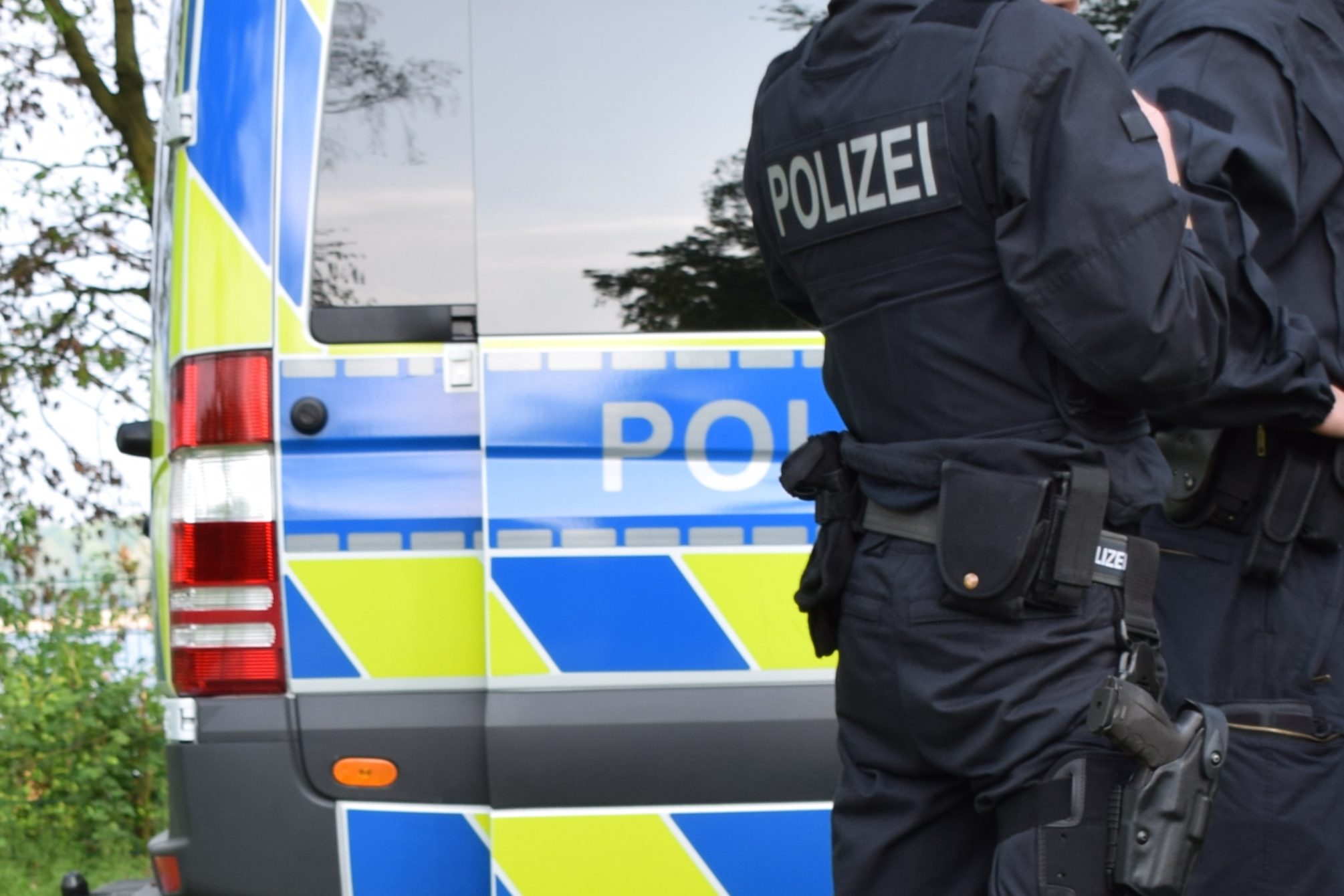 Bewaffnete Polizisten In Schwarzer Uniform Vor Einem Polizeiauto